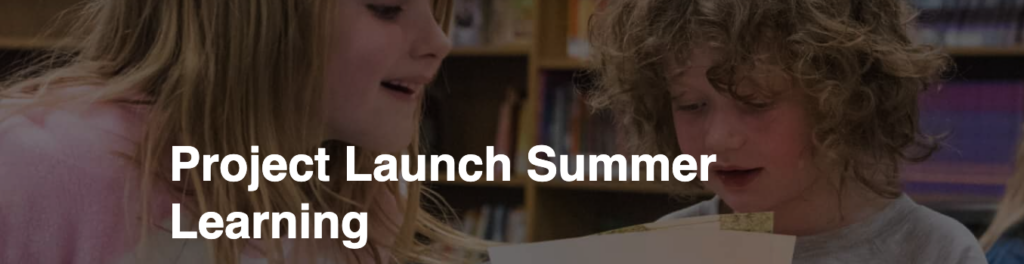 Two children engaged in a learning activity, smiling and reading a paper together in a classroom setting.